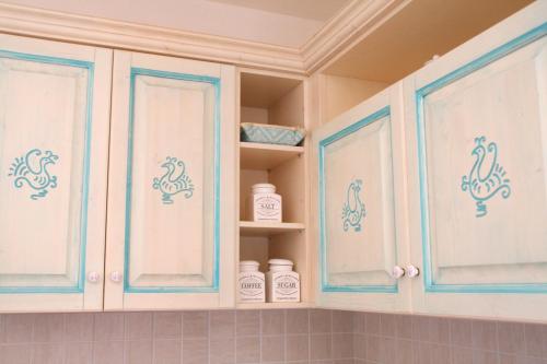 a kitchen cabinet with blue and white decals on it at Casa del Cervo in Ingurtosu