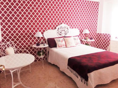 a bedroom with a bed and a red patterned wall at Vintage apartment in Córdoba