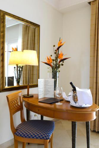 a table with a vase of flowers and a mirror at Vincci Saphir Palace & Spa in Hammamet