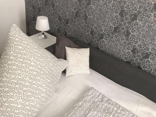 a bedroom with a bed with a headboard and pillows at Balthasar Neumann Speiserei & Gästehaus - Zentrum Brühl -E-Ladestation, nähe Phantasialand in Brühl