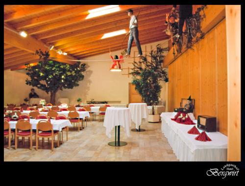 a man standing on a rope in a room with tables at Hotel Bergwirt in Herrieden