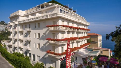 a white building with red flowers on the side of it at Hotel Continental in Sorrento