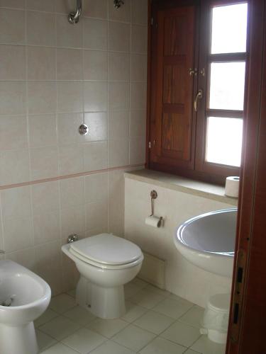 a bathroom with a toilet and a sink at Locanda La Rosa in Pauli Arbarei