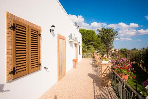 a balcony with a window and flowers on a building at Il Delfino in Pisticci
