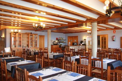 a restaurant with tables and chairs in a room at Hostal Gúdar in Gúdar