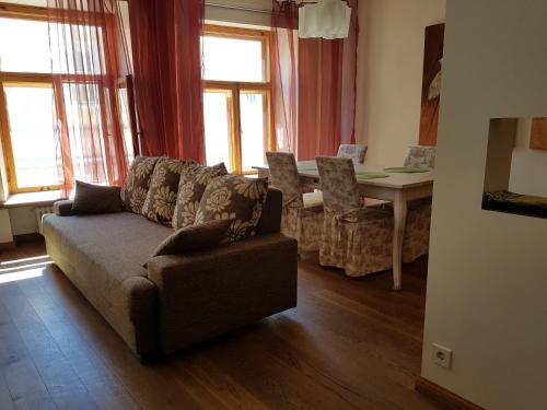 un soggiorno con divano e tavolo con finestre di Old Town Apartment a Tallinn