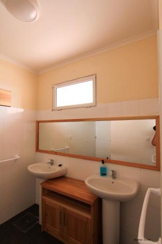 a bathroom with two sinks and a mirror at Quinta Do Norte in Capelas