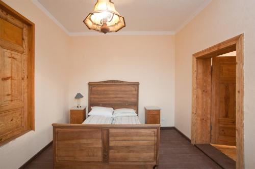 a bedroom with a bed with a wooden headboard at Gosciniec Kaszarnia Kamienne in Mirsk