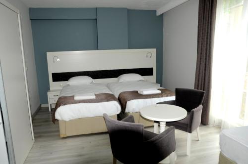 A bed or beds in a room at Pruva Prestige Hotel