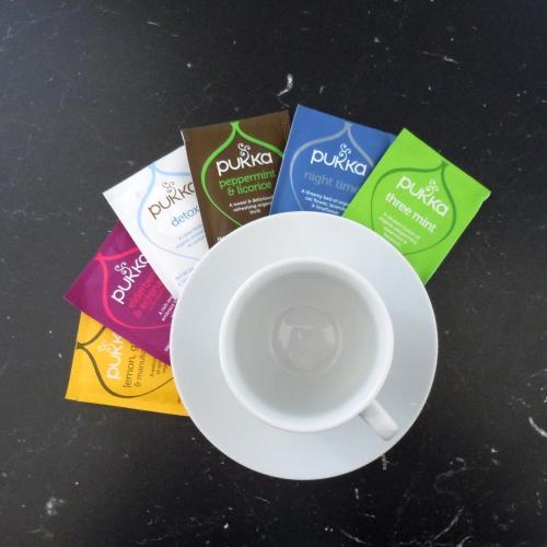 a cup of coffee sitting on a table with packets at Hvammból Guesthouse in Vík