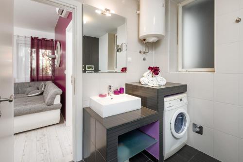 y baño con lavabo y lavadora. en My Place Apartments de Luxe, en Split