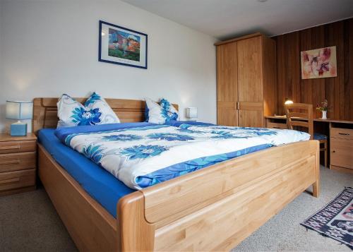ヴィンターベルクにあるHaus Deimelのベッドルーム1室(大型木製ベッド1台、青いシーツ付)
