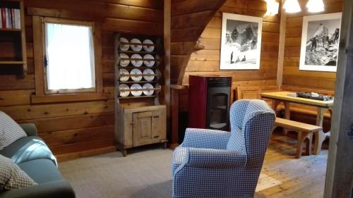 a living room with chairs and a stove in a cabin at Chalet des Mélèzes in Pila