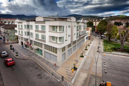 a large white building on a street in a city at Hotel Fernando Plaza in Pasto