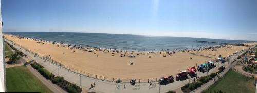 a crowd of people on a beach near the ocean at Sun & Sand Resort Oceanfront Suites in Virginia Beach