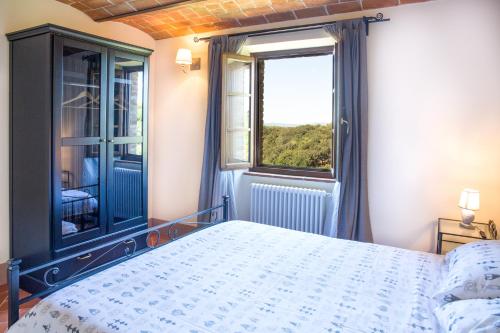 a bedroom with a bed and a window at Borgo alle Mura in Casale Marittimo