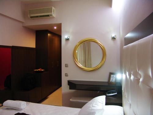 a bathroom with a mirror and a bed at Ellinis Hotel in Chania