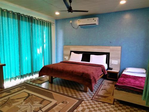 a bedroom with a bed and a blue wall at Forest Eco Lodge in Mount Ābu