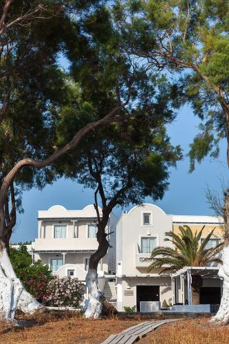a white building with trees in front of it at Memories Beach Hotel in Monolithos