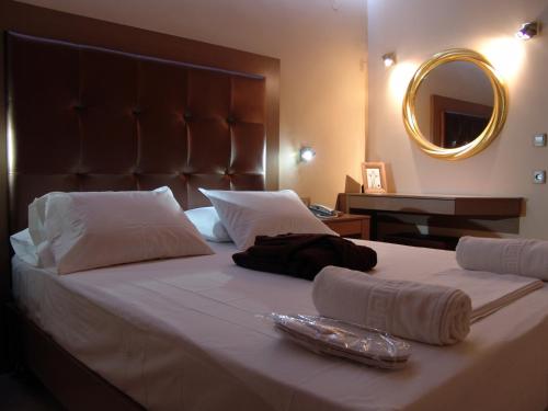 a large bed with two towels and a mirror at Ellinis Hotel in Chania