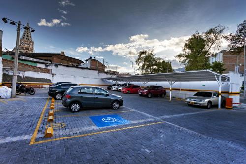 a parking lot with cars parked in front of a building at Hotel Fernando Plaza in Pasto