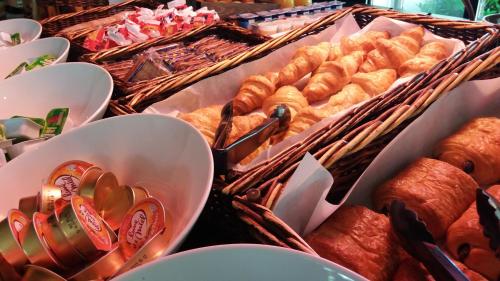 a buffet of pastries and breads in baskets at Campanile Bourg-En-Bresse ~ Viriat in Viriat