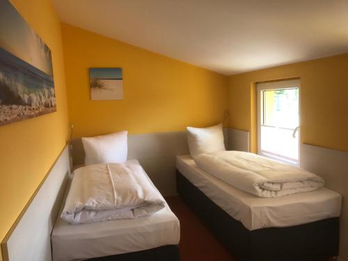 Küstenhaus Koserow tesisinde bir odada yatak veya yataklar