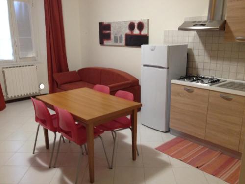 a small kitchen with a table and a refrigerator at Archi sul mare in Ancona