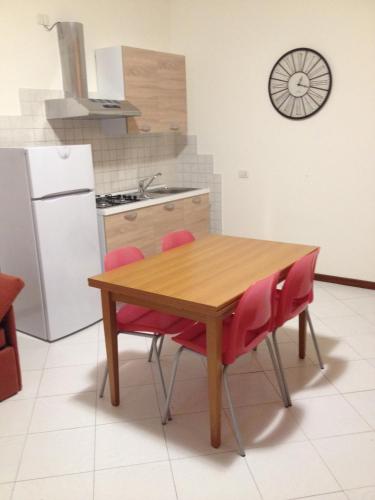 a kitchen with a wooden table and red chairs at Archi sul mare in Ancona