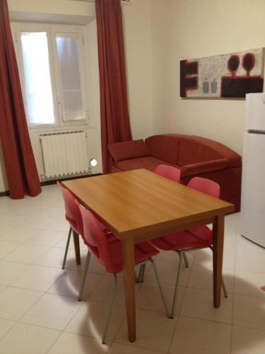 a living room with a wooden table and red chairs at Archi sul mare in Ancona