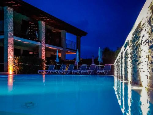 a swimming pool at night with chairs around it at Hotel Relais Agli Olivi in Lazise