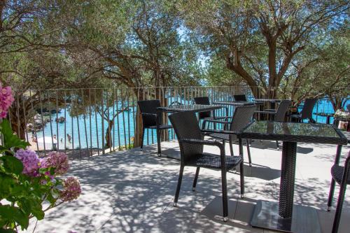 a patio with tables and chairs next to the water at Villa Rooms Mediteran in Borovići