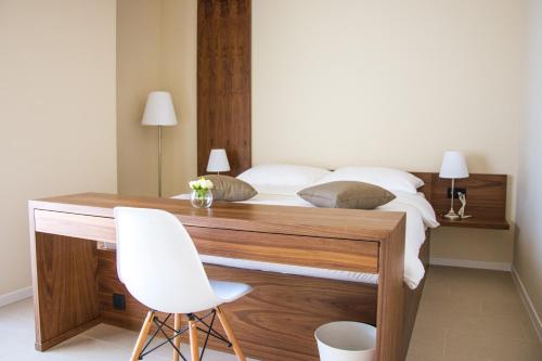 a bedroom with a bed with a desk and a white chair at Villa Rooms Mediteran in Borovići