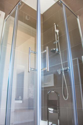 a bathroom with a shower with a glass door at Villa Rooms Mediteran in Borovići