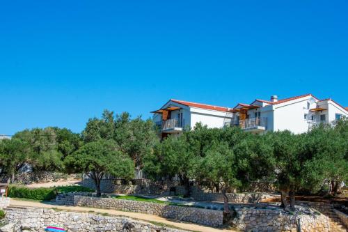 a house on top of a hill with trees at Villa Rooms Mediteran in Borovići