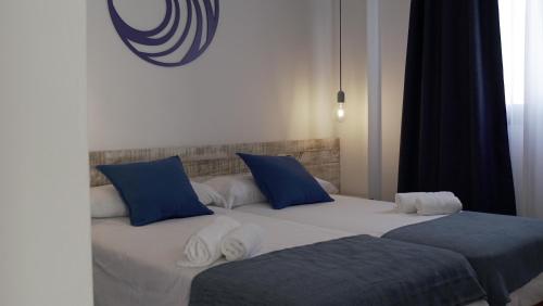 a white bed sitting in a bedroom next to a white wall at Aparthotel Fleming 50 - Adults Only in San Antonio
