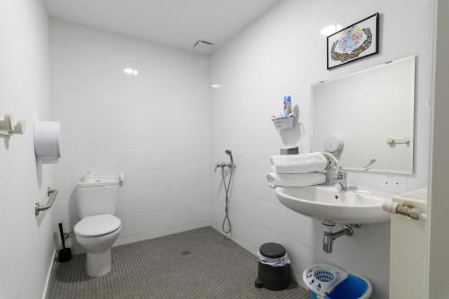 a white bathroom with a toilet and a sink at Albergue Valderrobres Auto check-in in Valderrobres