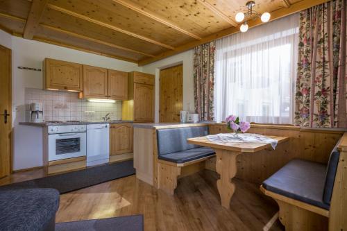 a kitchen with wooden cabinets and a table with flowers on it at Anja's Schönblick - Bed & Breakfast in Gerlos