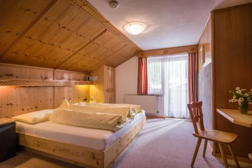 a bedroom with a large bed with a wooden ceiling at Anja's Schönblick - Bed & Breakfast in Gerlos