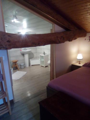 une chambre avec une salle de bain avec un lavabo et un lit dans l'établissement Manoir Le Cristal Futuroscope , grosses reductions sur les nuitées et le parc !, à Beaumont