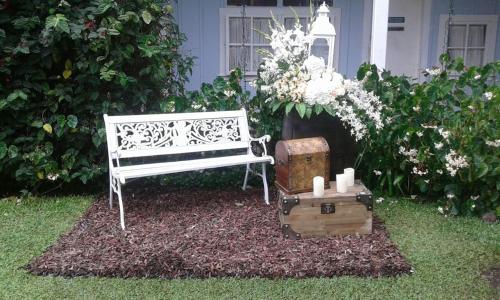 a white bench sitting in the grass with candles and flowers at Hotel Panamonte in Boquete