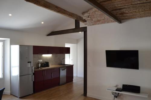 Il comprend une cuisine équipée d'un réfrigérateur et une télévision murale. dans l'établissement 2 pièces Vagliano, à Cannes