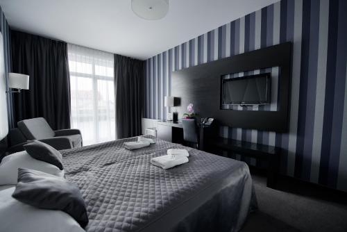 a hotel room with a bed and a tv at Hotel Grafit in Kielce