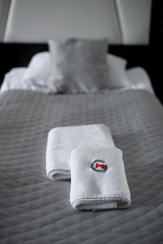 two beds with white towels on top of them at Hotel Grafit in Kielce