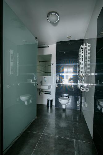 a bathroom with two sinks and a toilet at Hotel Grafit in Kielce