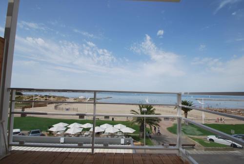a view of the beach from the balcony of a resort at Hôtel Café Miramar in Le Grau-du-Roi