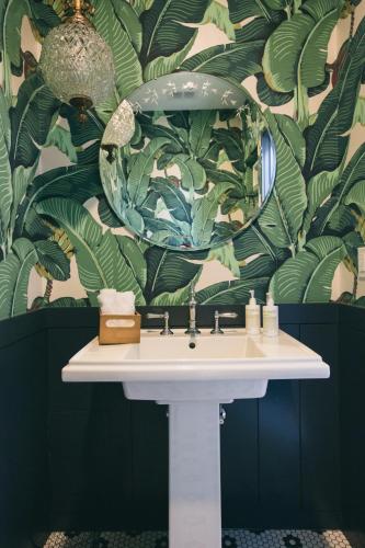 a bathroom with a sink and a large mirror at The Publishing House Bed and Breakfast in Chicago