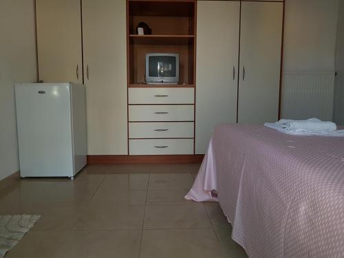 a room with a bed and a tv and a refrigerator at Apartments Rudi in Orikum