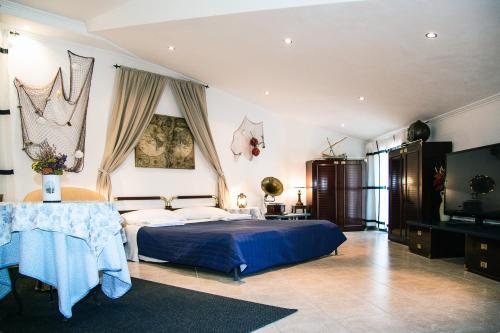 1 dormitorio con 1 cama azul y TV en Hotel Overland, en Toirano