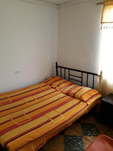 a bedroom with a bed with a striped comforter at Residencias Escorial in Palmira